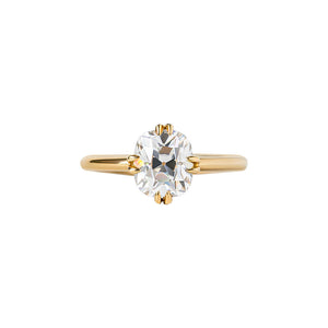 Yellow gold engagement ring with compass-set NSEW double claw prongs, set with an Old Mine Cut cushion moissanite or lab diamond. Knife edge band and integrated basket. Front view.
