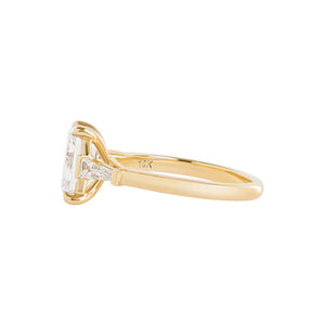 Yellow gold engagement ring set with an emerald cut lab diamond and tapered baguette sides. Cathedral set. Front view