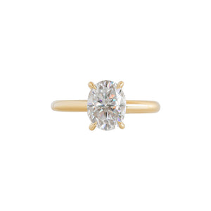 Yellow gold four-prong classic solitaire peg head oval moissanite or lab diamond engagement ring on a white background. Front view.