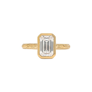 Emerald cut bezel engagement ring with a hand engraved floral band 