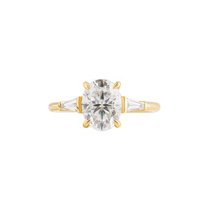 Oval yellow gold engagement ring with tapered baguette lab diamonds.