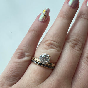 Yellow gold Freya Round solitaire Engagement Ring and yellow gold Brooklyn Half Eternity Wedding Band Stacked on a Hand