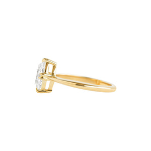 Yellow gold engagement ring with compass-set NSEW double claw prongs, set with an oval moissanite or lab diamond. Knife edge band and integrated basket. Side view.