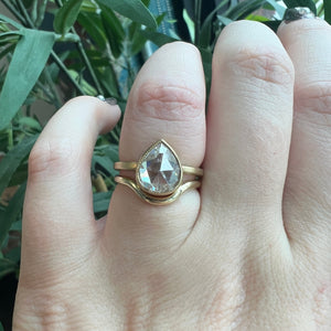 Shown on hand: Ava Pear Rose Cut engagement ring stacked with dramatic curved yellow gold wedding band.