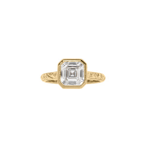 Yellow gold Asscher cut bezel engagement ring with a hand engraved floral band. Front view.