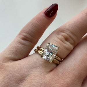 Jackson Radiant Engagement Ring shown on hand with hand engraved gold Flora wedding band