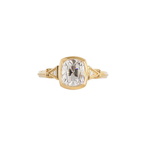 Yellow gold bezel-set antique-inspired Old Mine Cut or antique cushion engagement ring on a white background. Ring has hand-carved milgrain on the bezel and side triangles with accent lab diamonds. Integrated basket, antique fluting on shank. Front view.