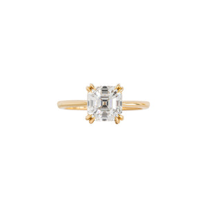 Double claw prong yellow gold Asscher cut moissanite or lab diamond solitaire engagement ring on a white background. Knife edge band with an integrated basket. Front view.