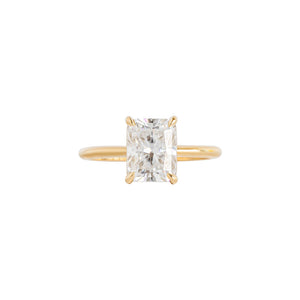 Yellow gold four-prong classic solitaire peg head radiant moissanite or lab diamond engagement ring on a white background. Front view.