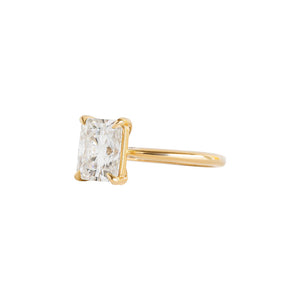 Yellow gold four-prong classic solitaire peg head radiant moissanite or lab diamond engagement ring on a white background. Side view.