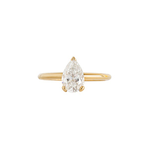Yellow gold solitaire pear moissanite or lab diamond engagement ring with a V prong and two flat prongs on a white background. Integrated basket. Front view.