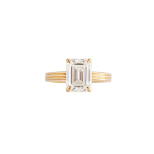 Yellow gold emerald moissanite or lab diamond engagement ring on a grooved band with ridges, on a white background. Cathedral. Front view. 