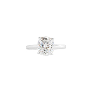 White gold four-prong classic solitaire peg head elongated cushion moissanite or lab diamond engagement ring on a white background. Front view.