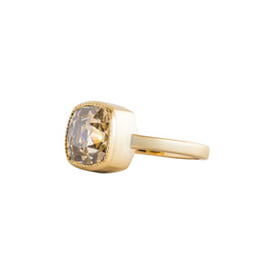 Yellow gold bezel-set engagement ring with hand-carved milgrain and integrated basket, on a white background. Set with a brown Old Mine Cut or antique cushion moissanite or lab diamond. Side view.