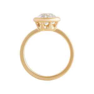 Yellow gold bezel-set engagement ring with hand-carved milgrain and integrated basket, on a white background. Set with an Old European Cut round moissanite or lab diamond. Gallery view.