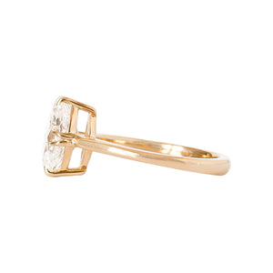 Yellow gold engagement ring with compass-set NSEW double claw prongs, set with an antique marquise moissanite or lab diamond. Knife edge band and integrated basket. Side view.