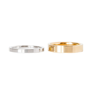 White and yellow gold flat wedding bands on a white background.