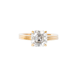 Yellow gold Asscher moissanite or lab diamond engagement ring on a grooved band with ridges, on a white background. Cathedral setting. Front view. 