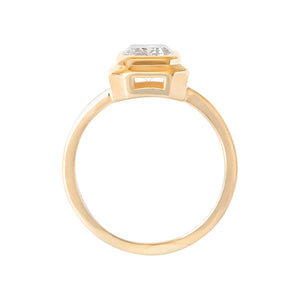 Yellow gold emerald cut moissanite or lab diamond engagement ring with a wide stepped bezel setting and an integrated basket on a white background. Gallery view.