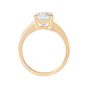 Yellow gold Asscher moissanite or lab diamond engagement ring on a grooved band with ridges, on a white background. Integrated basket. Gallery view. 