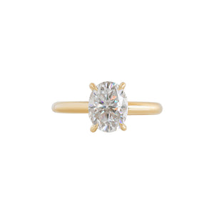 Yellow gold four-prong classic solitaire peg head oval moissanite or lab diamond engagement ring on a white background. Front view.