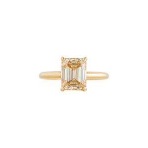 Yellow gold four-prong classic solitaire peg head emerald moissanite or lab diamond engagement ring on a white background. Shown with a champagne moissanite. Front view.