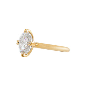 Yellow gold, compass-set NSEW double claw prong solitaire engagement ring on a white background. Side view.