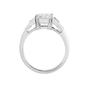 White gold emerald cut moissanite or lab diamond engagement ring with four vertical lab diamond baguette accent stones, on a white background. Center stone has double prongs, baguettes are bezel-set with hand-carved milgrain on the bezel. Gallery view.