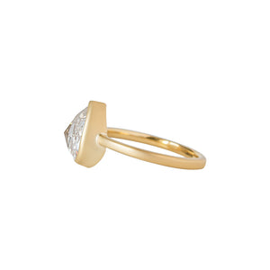 Yellow gold bezel-set engagement ring with hand-carved milgrain and integrated basket, on a white background. Set with a rose cut chubby pear moissanite or lab diamond. Side view. 