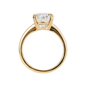  Double claw prong yellow gold oval cut moissanite or lab diamond solitaire engagement ring on a white background. Knife edge band with an integrated basket. Gallery view.