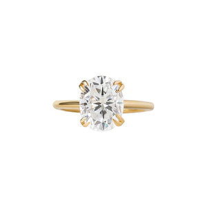  Double claw prong yellow gold oval cut moissanite or lab diamond solitaire engagement ring on a white background. Knife edge band with an integrated basket. Front view.