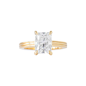 Yellow gold radiant moissanite or lab diamond engagement ring on a grooved band with ridges, on a white background. Integrated basket. Front view. 