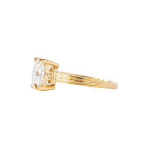 Yellow gold oval moissanite or lab diamond engagement ring on a grooved band with ridges, on a white background. Integrated basket. Side view. 
