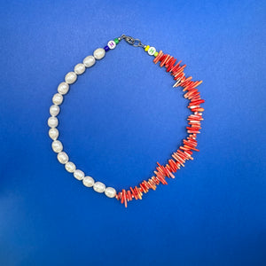 Handmade mixed media necklace with white pearl and red orange coral.